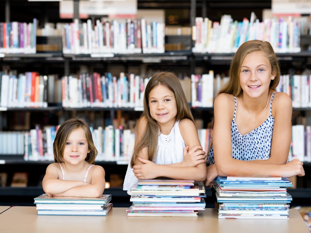 Little girls reading books in library-1