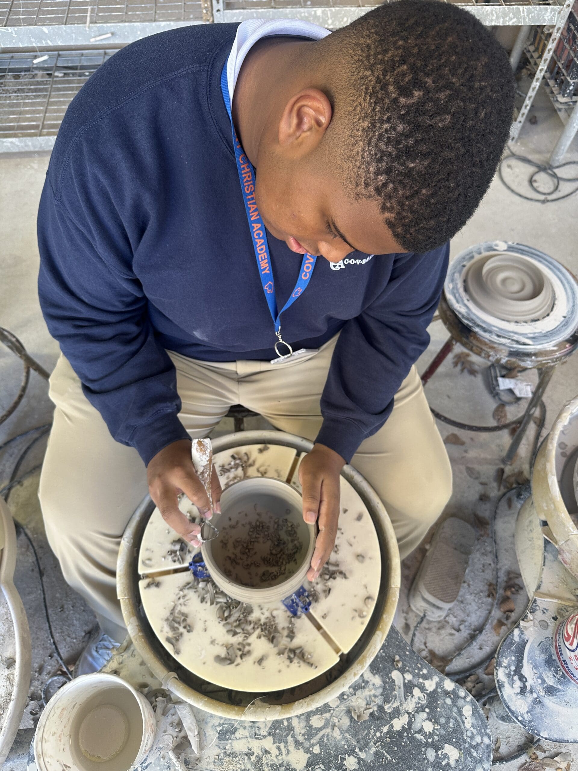 high school boy on pottery wheel